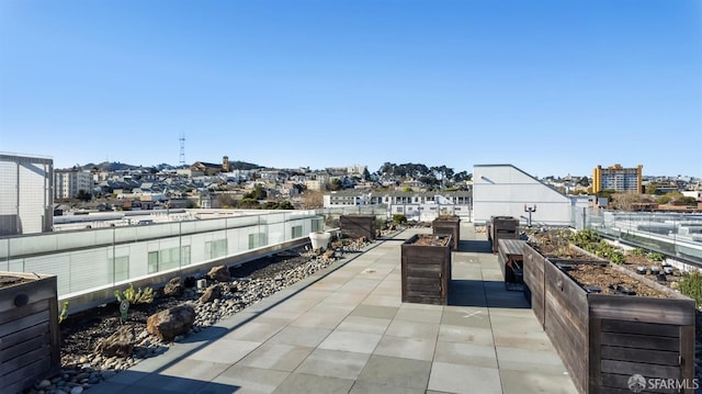 view of patio / terrace featuring a garden, fence, a city view, and area for grilling