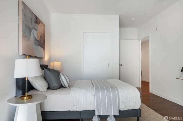 bedroom with baseboards and wood finished floors