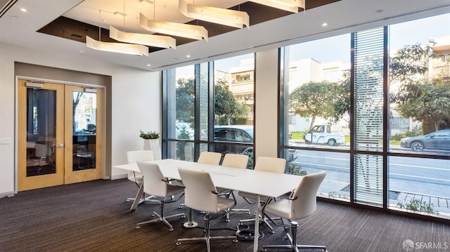 interior space featuring dark colored carpet, french doors, and plenty of natural light