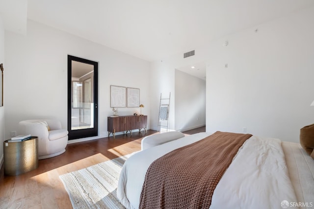 bedroom featuring visible vents and wood finished floors