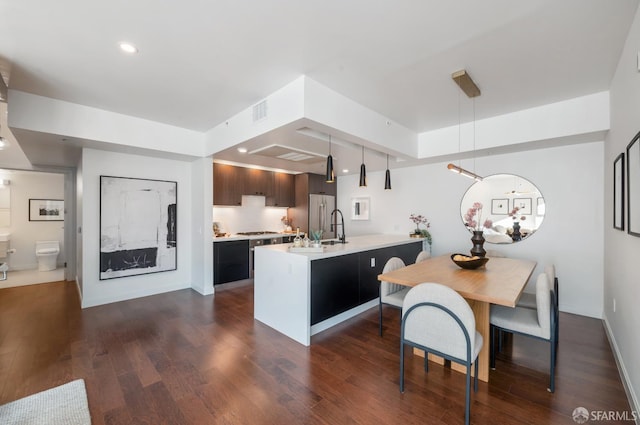 kitchen with recessed lighting, stainless steel appliances, visible vents, light countertops, and dark wood-style floors