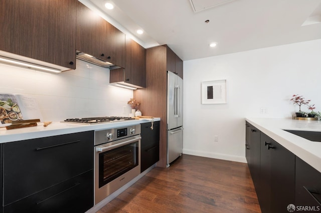 kitchen featuring stainless steel appliances, backsplash, and light countertops