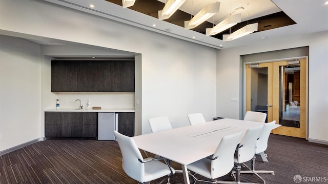 dining area featuring french doors, indoor wet bar, and baseboards