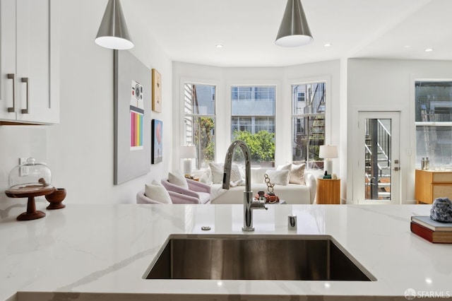 2237 Bryant St Lower, Lower, San Francisco, CA 94110 - kitchen featuring a sink, open floor plan, light stone counters, and white cabinetry