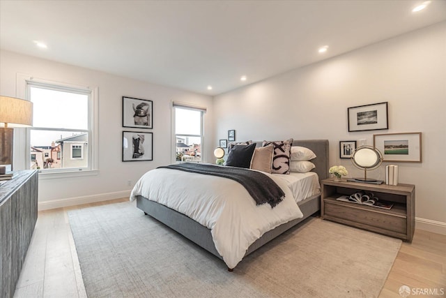 bedroom featuring baseboards, multiple windows, recessed lighting, and light wood-style floors