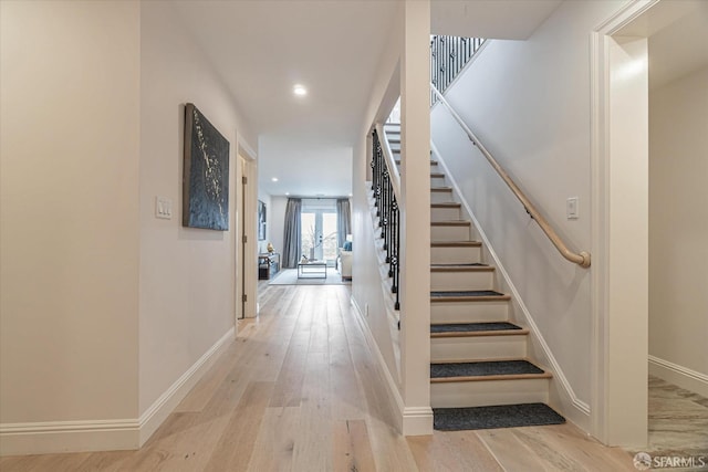 interior space with light wood-style floors, recessed lighting, stairway, and baseboards