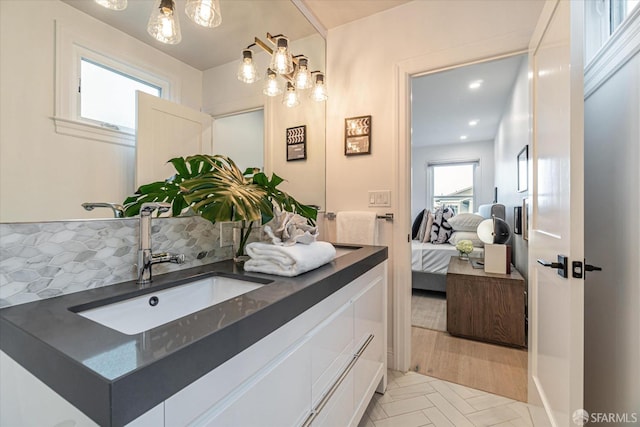 bathroom featuring ensuite bath, backsplash, and vanity