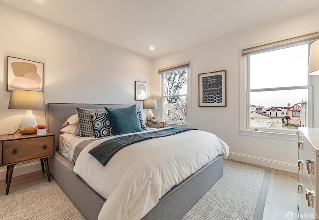 bedroom featuring recessed lighting, multiple windows, light wood finished floors, and baseboards