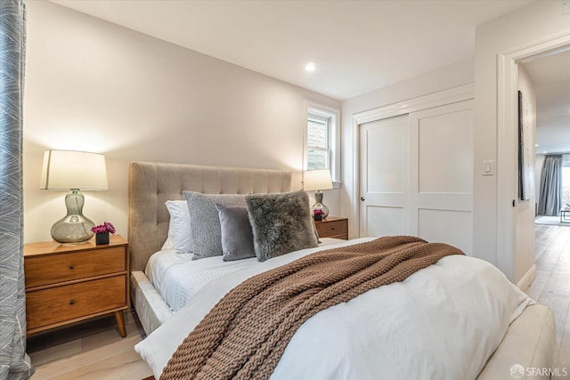 bedroom featuring a closet, light wood-style flooring, and recessed lighting