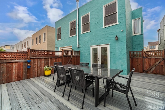 wooden deck with outdoor dining space and a gate