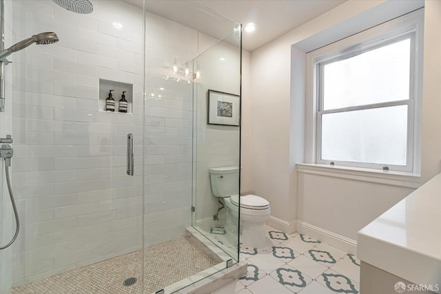 bathroom with a shower stall, toilet, and baseboards