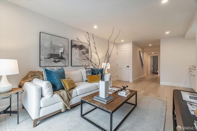 living area featuring light wood-type flooring, baseboards, and recessed lighting