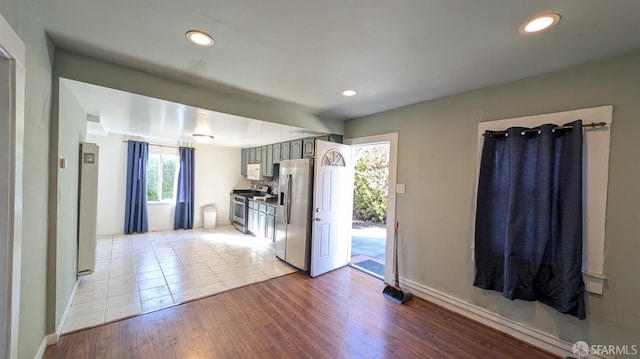 kitchen with gray cabinets, light hardwood / wood-style floors, and stainless steel appliances