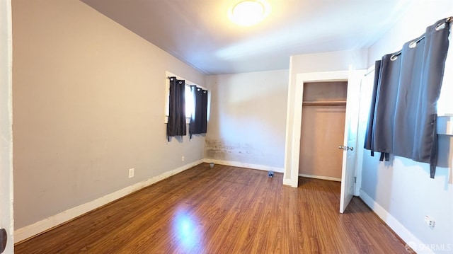 unfurnished bedroom with hardwood / wood-style floors and a closet