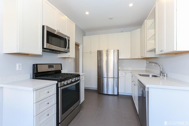 kitchen featuring open shelves, a sink, light countertops, white cabinets, and stainless steel appliances