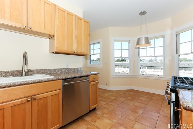 kitchen with light tile patterned flooring, appliances with stainless steel finishes, a sink, decorative light fixtures, and baseboards