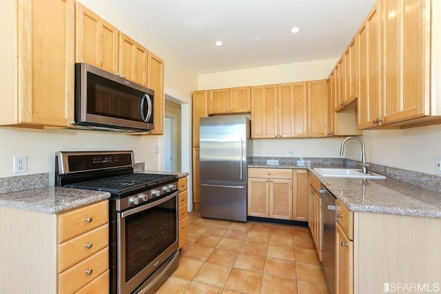 kitchen featuring light brown cabinets, recessed lighting, a sink, light tile patterned floors, and stainless steel appliances