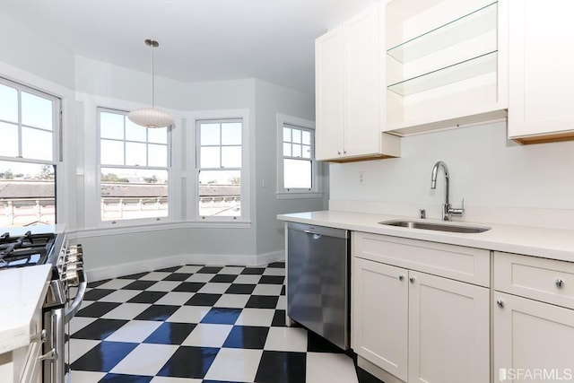 kitchen with light countertops, white cabinets, dark floors, a sink, and stainless steel appliances