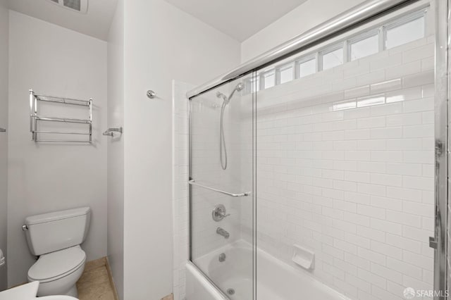 bathroom featuring toilet and combined bath / shower with glass door