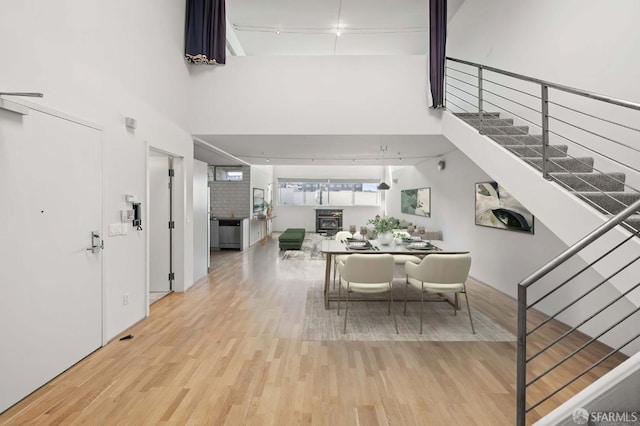 dining area with a towering ceiling and wood finished floors