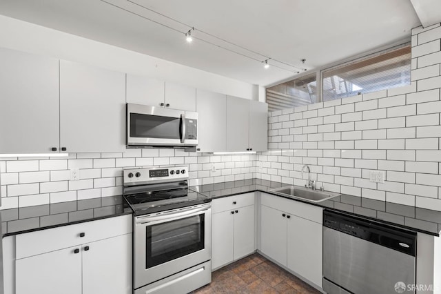 kitchen featuring a sink, dark countertops, and appliances with stainless steel finishes