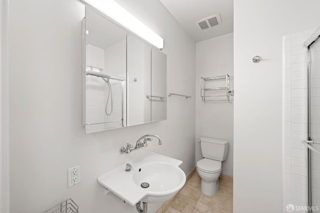 bathroom with a shower with shower door, visible vents, a sink, tile patterned floors, and toilet