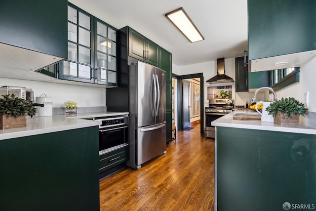 831 45th Ave, San Francisco, CA 94121 - kitchen with wall chimney exhaust hood, appliances with stainless steel finishes, dark wood-type flooring, glass insert cabinets, and light countertops