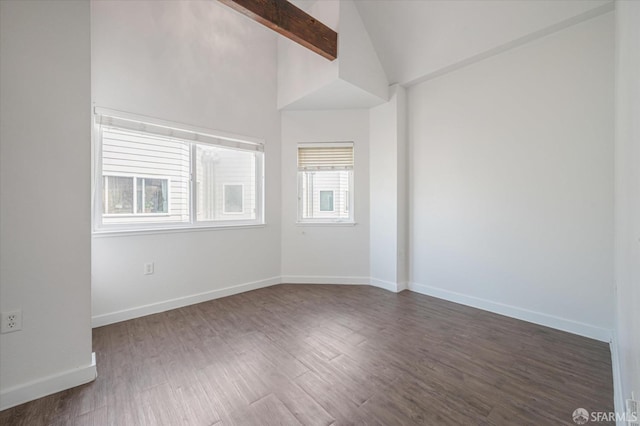 spare room with vaulted ceiling with beams and dark hardwood / wood-style floors