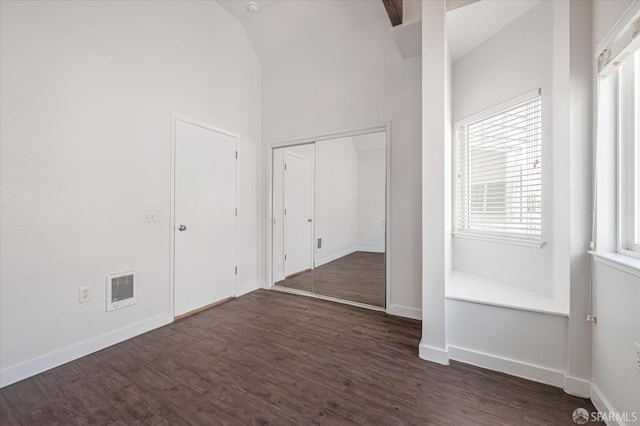 interior space featuring dark wood-type flooring and vaulted ceiling