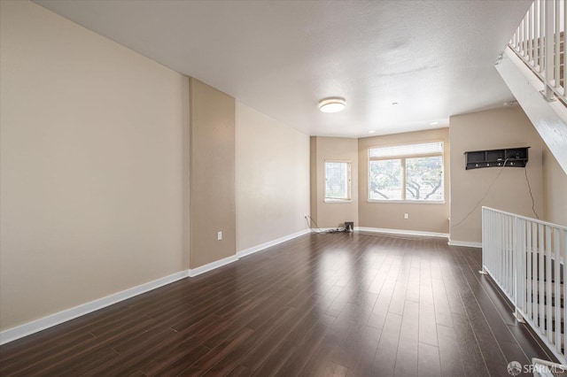 spare room with a textured ceiling and dark wood-type flooring