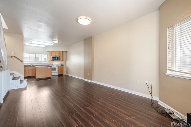 unfurnished living room with dark hardwood / wood-style flooring and sink