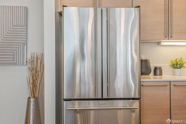 kitchen featuring stainless steel fridge and light brown cabinetry