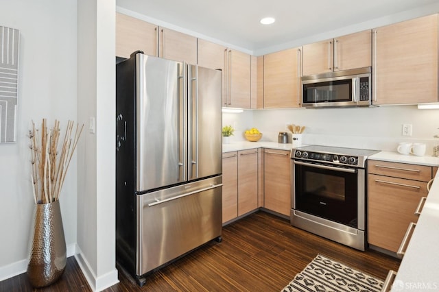 kitchen with dark hardwood / wood-style flooring, stainless steel appliances, and light brown cabinets