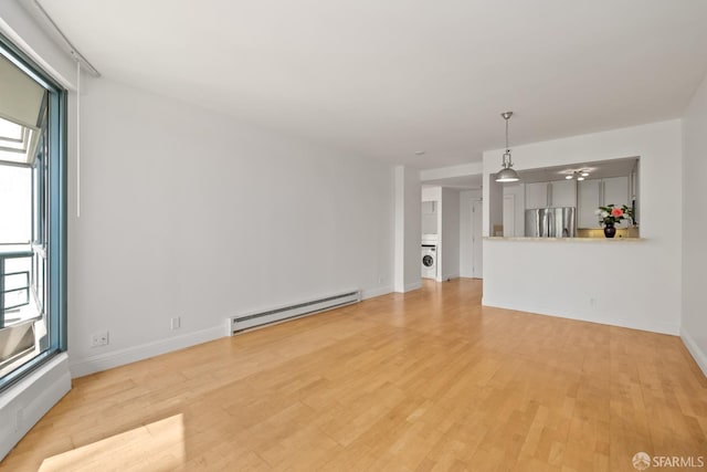 unfurnished living room with light wood-type flooring, a baseboard radiator, and baseboards
