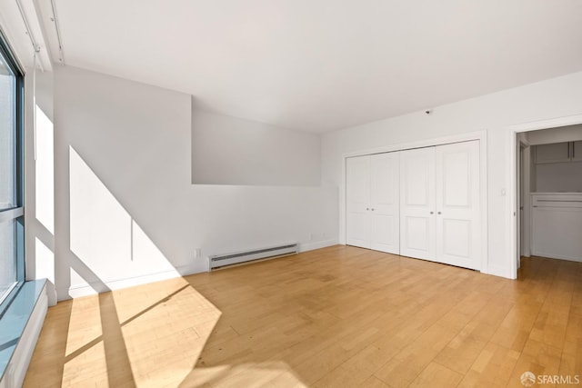 interior space featuring a baseboard heating unit, light wood-style floors, a closet, and baseboard heating