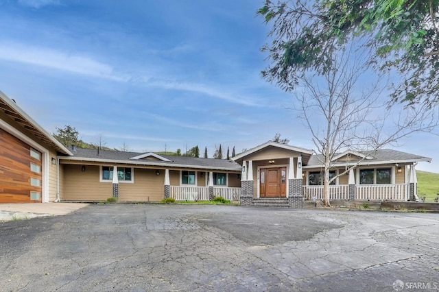 view of front of property with covered porch, driveway, and a garage