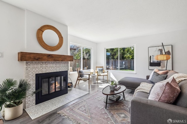 living area with wood finished floors and a tile fireplace