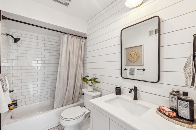 bathroom with vanity, wooden walls, visible vents, shower / tub combo, and toilet