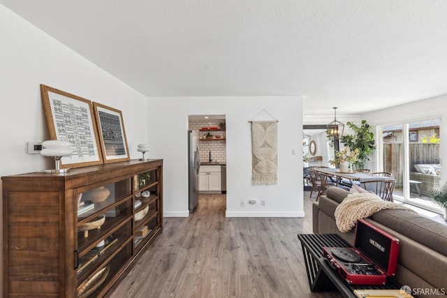 living area with baseboards and light wood finished floors