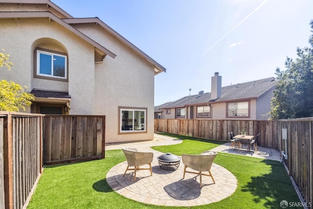 back of house featuring a patio area, stucco siding, a lawn, and a fenced backyard