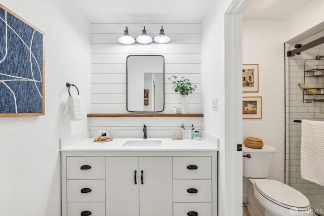 full bathroom featuring toilet, walk in shower, and vanity