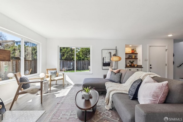 living room featuring plenty of natural light, baseboards, and wood finished floors