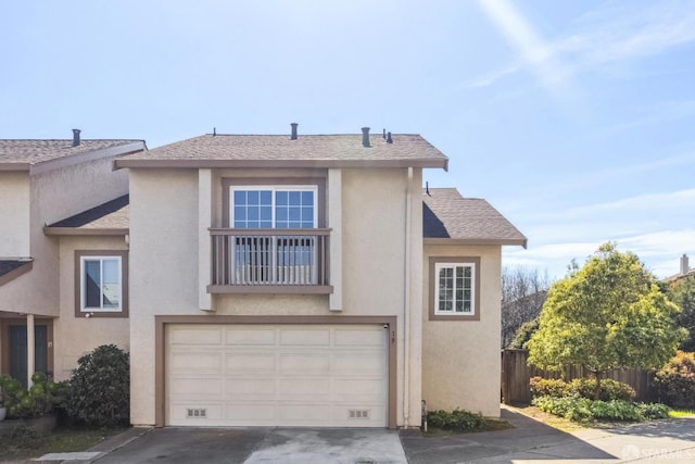 view of front facade featuring stucco siding, driveway, fence, roof with shingles, and an attached garage