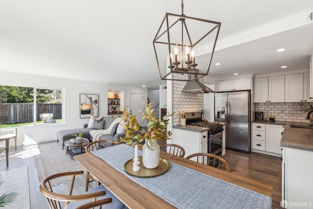 dining room with recessed lighting, dark wood-type flooring, and an inviting chandelier