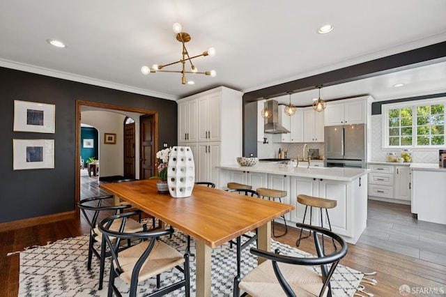 20 Rossmoor Dr, San Francisco, CA 94132 - dining area with arched walkways, ornamental molding, light wood-style floors, recessed lighting, and a chandelier