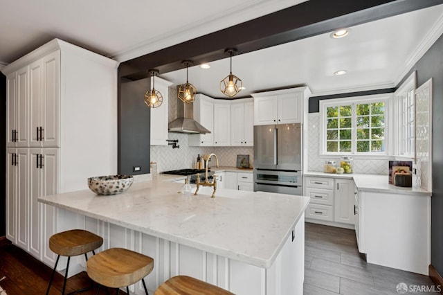 20 Rossmoor Dr, San Francisco, CA 94132 - kitchen featuring freestanding refrigerator, wall chimney range hood, a peninsula, white cabinetry, and a kitchen bar