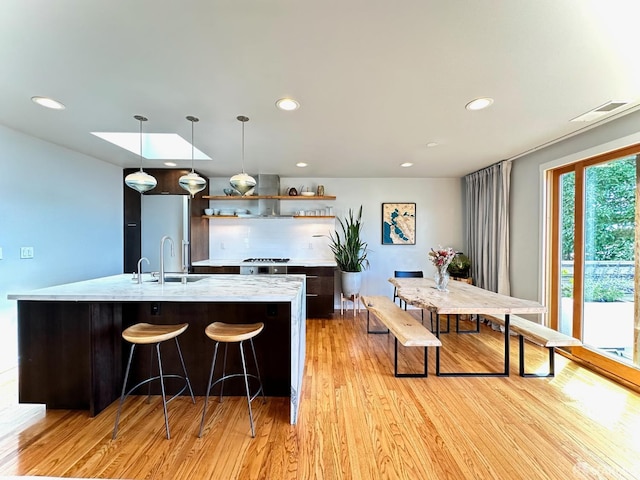 2543 44th Ave, San Francisco, CA 94116 - kitchen with open shelves, light wood-style floors, a sink, recessed lighting, and an island with sink