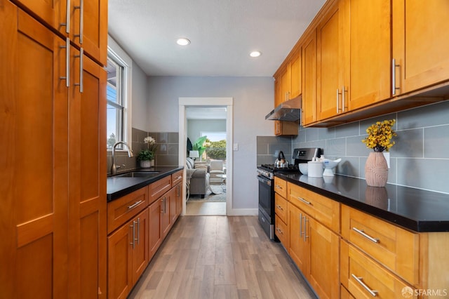3644 Redding St, Oakland, CA 94619 - kitchen with gas range oven, under cabinet range hood, brown cabinetry, backsplash, and dark countertops