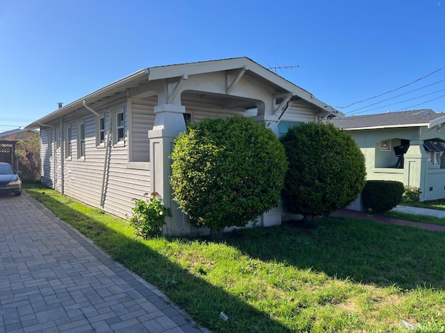 view of side of home with a lawn