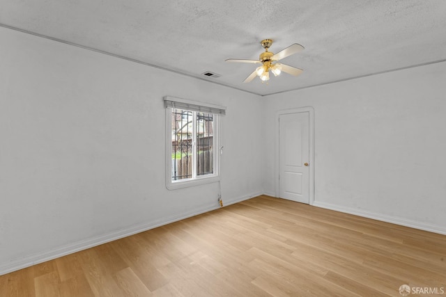 unfurnished room featuring ceiling fan, visible vents, a textured ceiling, and light wood-style flooring